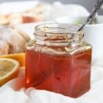 lemon jelly in a small jar, lemons beside it.