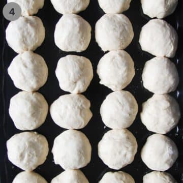 many balls of yeast dough on a tray before raising.