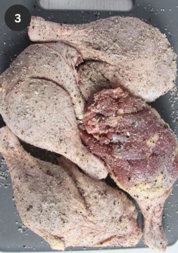 four raw duck legs rubbed with salt and spices.