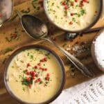 cream of turkey soup in two bowls with red peppercorns