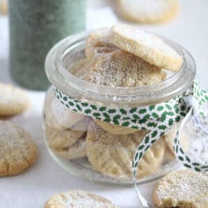 eggless almond cookies in a small mason jar with a ribbon around it.