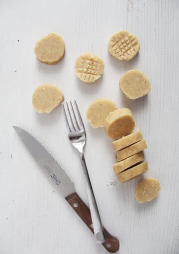 cookie dough slices, a small knife and a fork for making patterns on the cookies.