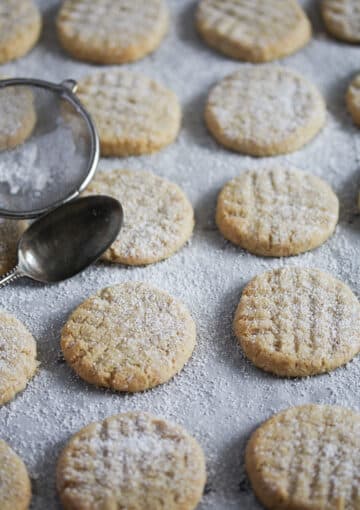 cookies sprinkled with icing sugar on a baking sheet.