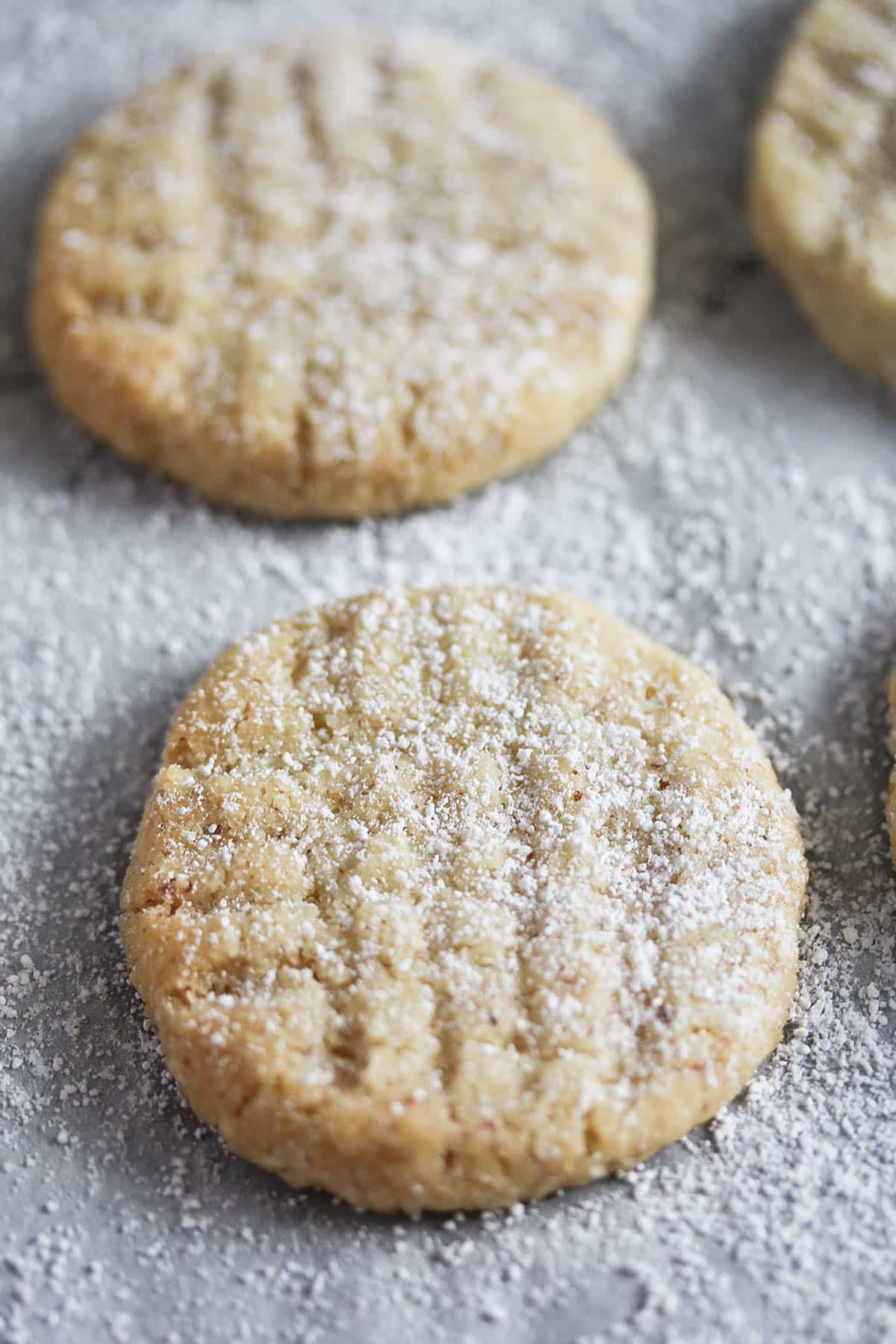 close up of two criss-crossed eggless sugar cookies on parchment paper.
