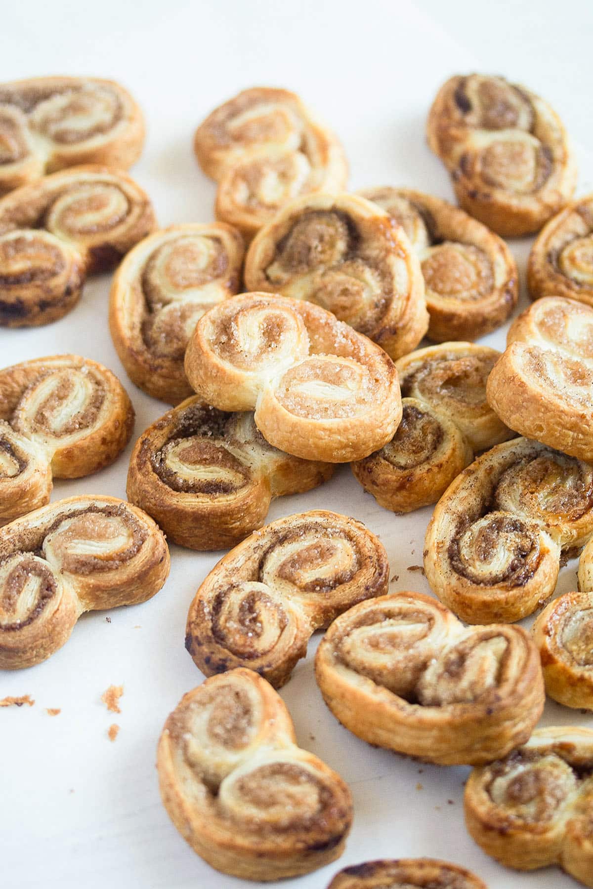 many palmiers cookies with cinnamon and sugar on the table.