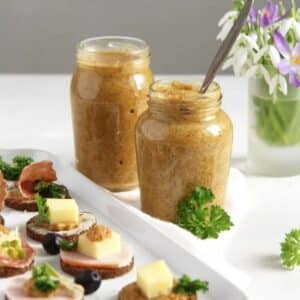 two jars of homemade orange mustard and a platter of canapes.