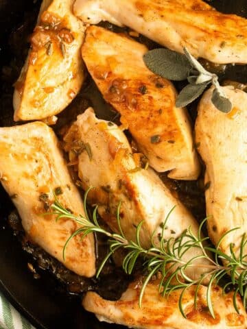 italian herb chicken with a sprig of rosemary on top.