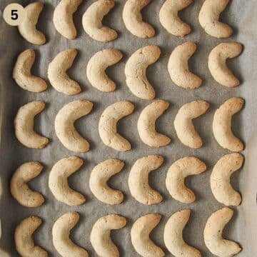 baked vanille kipferl on a lined baking sheet.