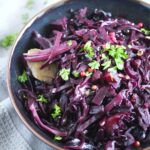 pinterest image of a dark bowl with purple cabbage and herbs.