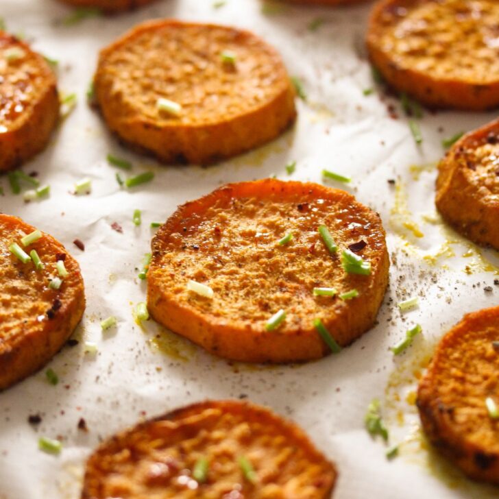 many baked sweet potato slices sprinkled with pepper and chives.