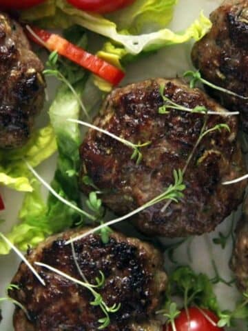 shiny and juicy beef zucchini meatballs sprinkled with herbs.