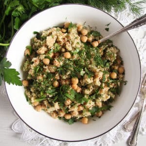 vegan bulgur wheat salad in a white bowl with a spoon in it.
