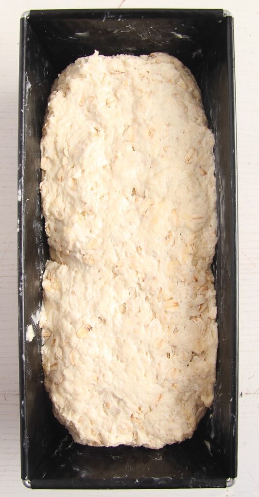 dough for oatmeal bread in a loaf tin