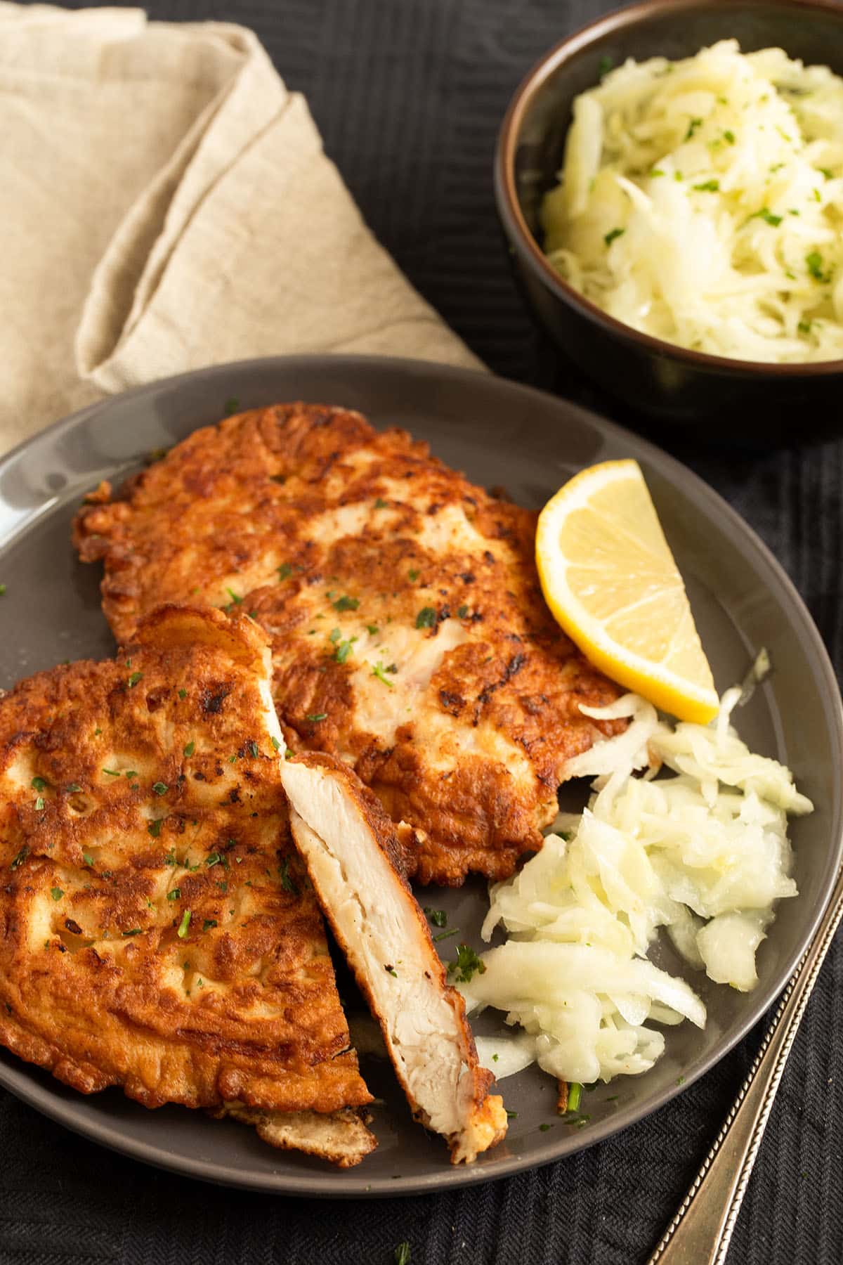pancake-battered chicken on a plate, one piece cut to show the meat.