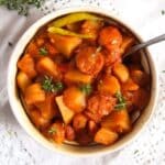 romanian potato sausage stew in a traditional bowl.