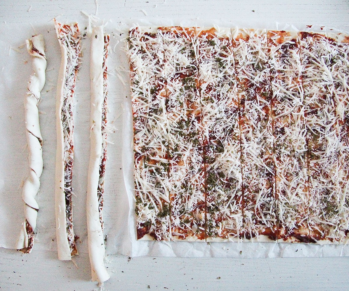 puff pastry smeared with tomato paste and parmesan, some of it rolled into twists.