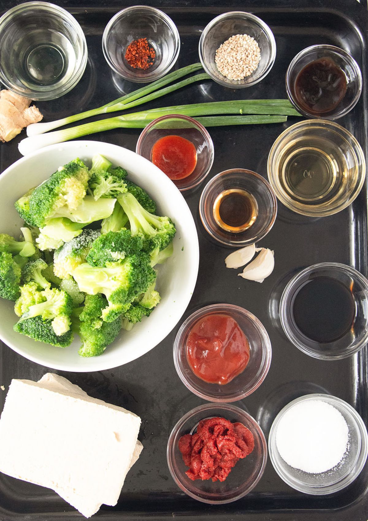 all the ingredients for making stir fry with broccoli, tofu and sweet and sour sauce.