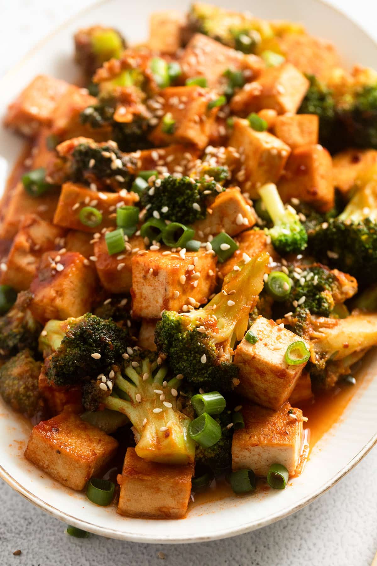 close up of broccoli and tofu in sweet sour sauce.