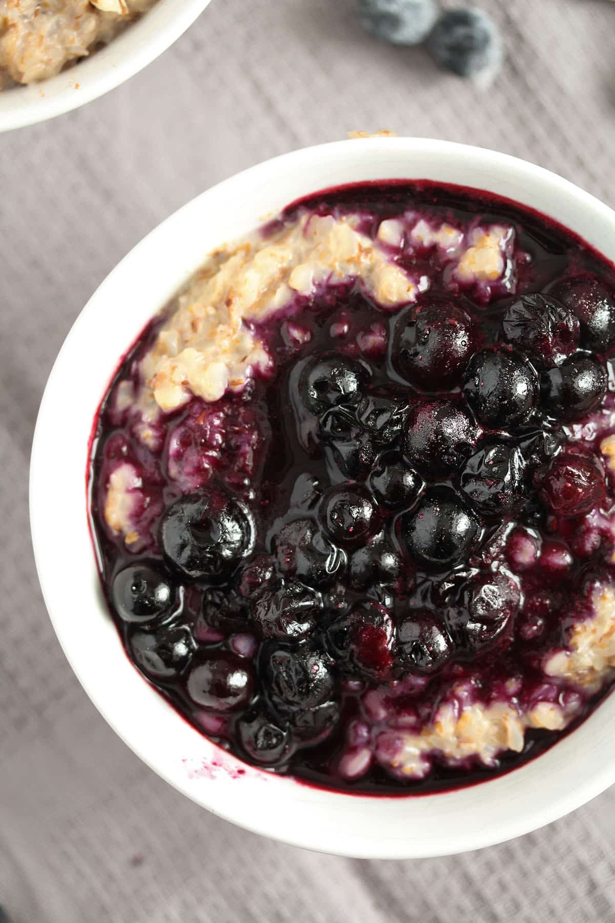 a bowl of buckwheat porridge topped with glossy blueberry sauce for breakfast.