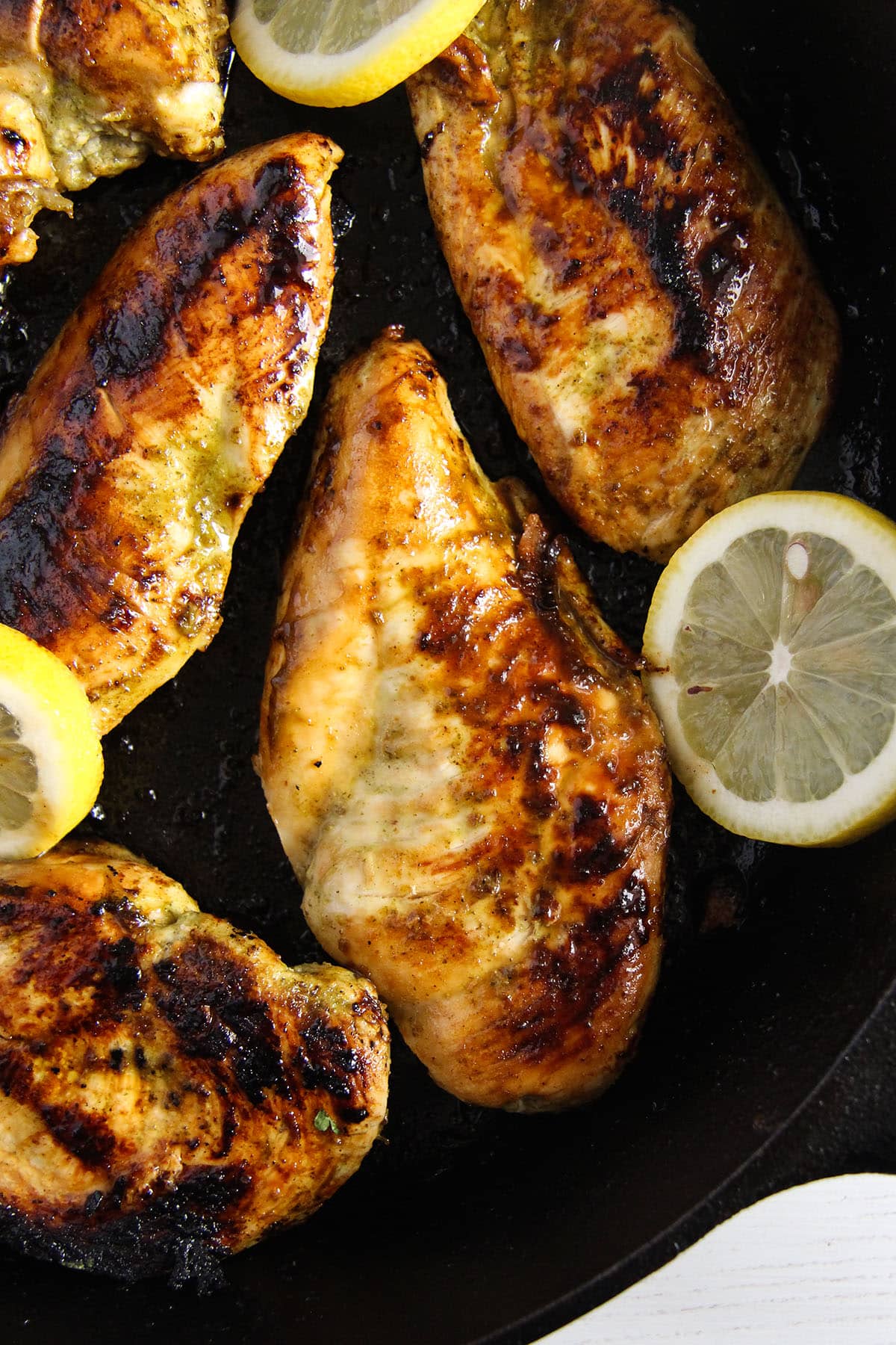seared chicken breast and lemon slices in a cast iron skillet.
