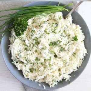 german coleslaw, chives, and fresh parsley in a bowl with a spoon in it.