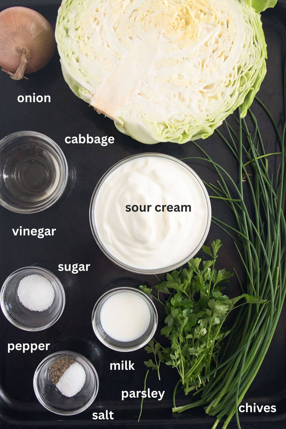 labeled ingredients for making german cabbage salad with sour cream and herbs.