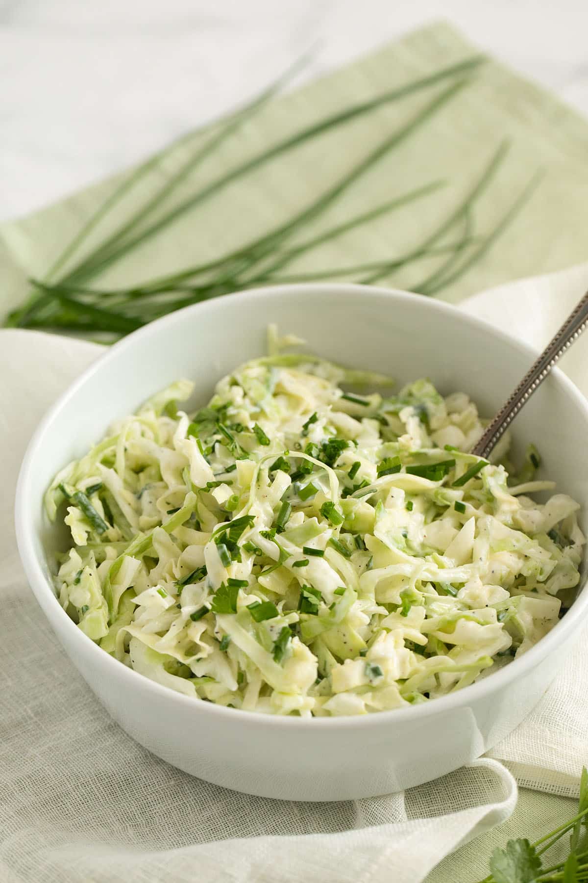 bowl of coleslaw german style in a bowl with a fork in it.