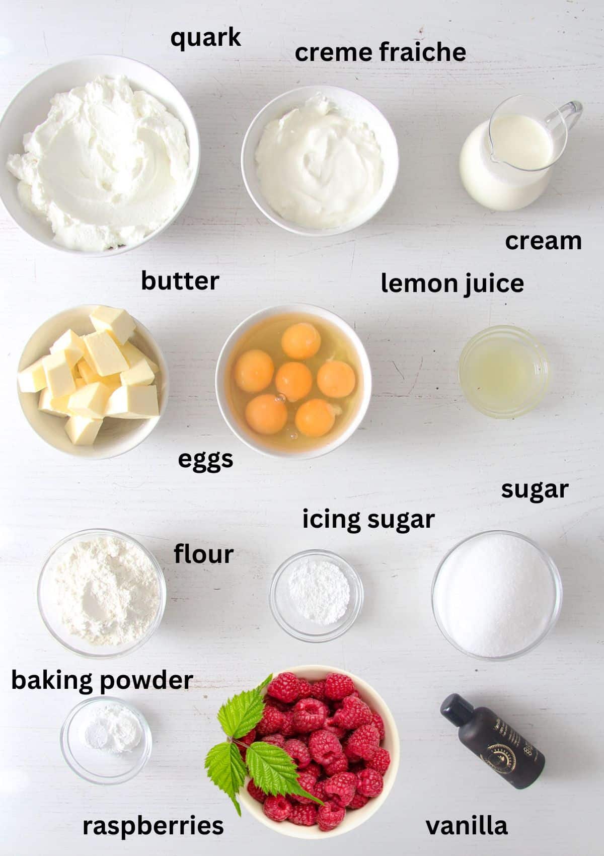 labeled ingredients for making cheesecake with fresh raspberries.