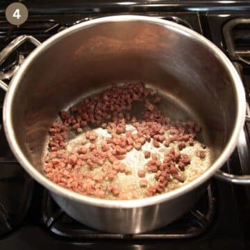 browning bacon cubes in a soup pot to make soup with bone broth and vegetables.