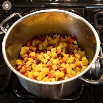 sauteing potatoes and vegetables in a pot to make soup.