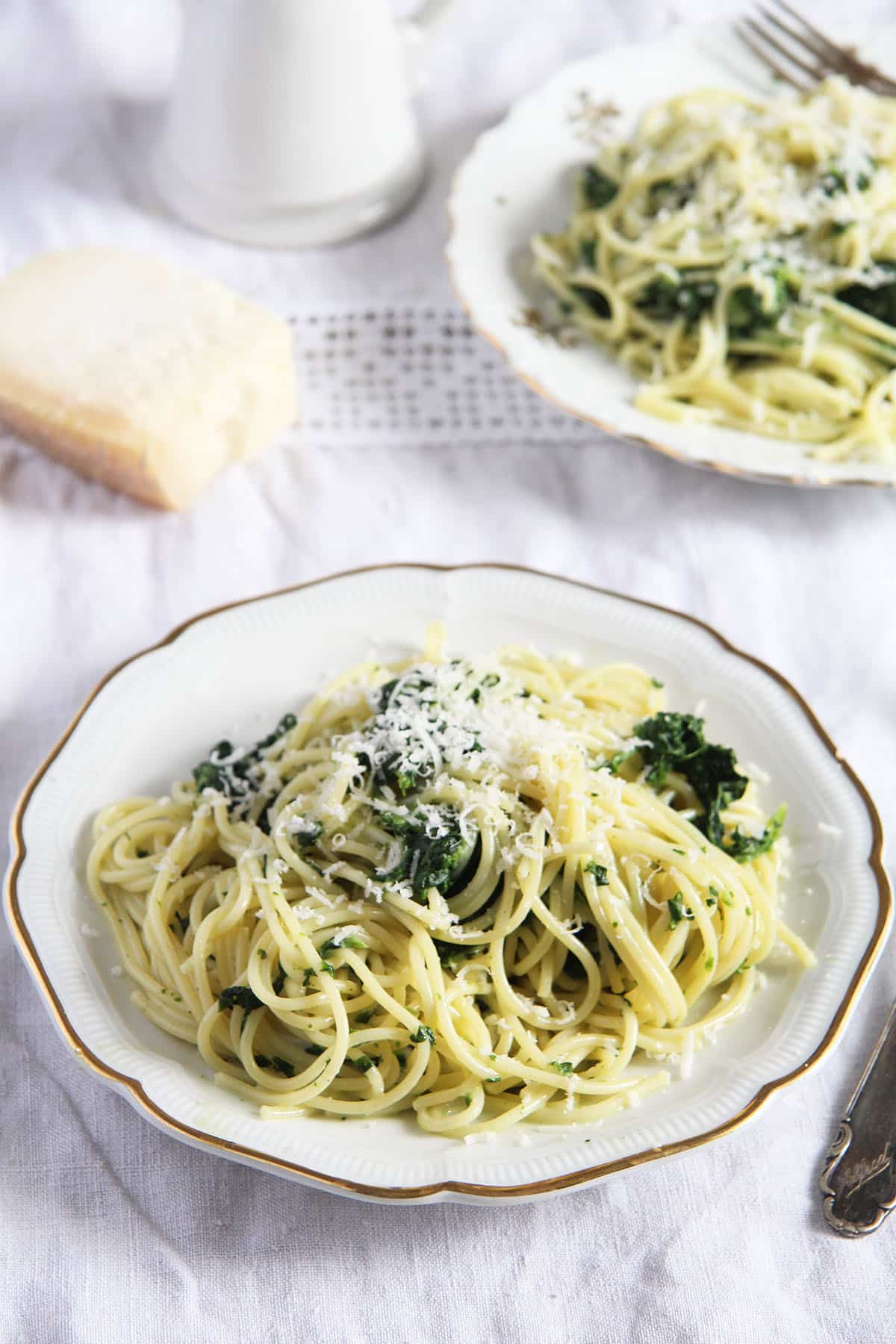 two plates with spaghetti and frozen spinach sauce.