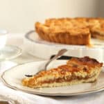 a slice of harry potter's treacle tart and the rest of the tart on a platter behind.