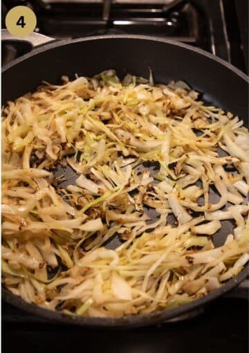 sauteing sliced cabbage in a large pan.