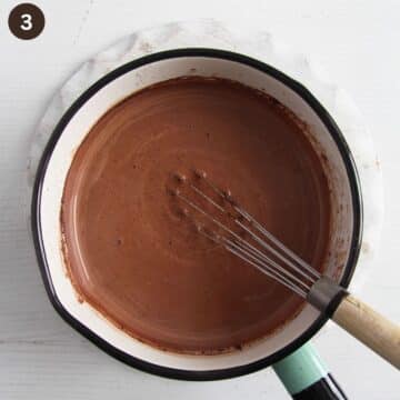melted chocolate for making hot chocolate in a small saucepan with a whisk in it.