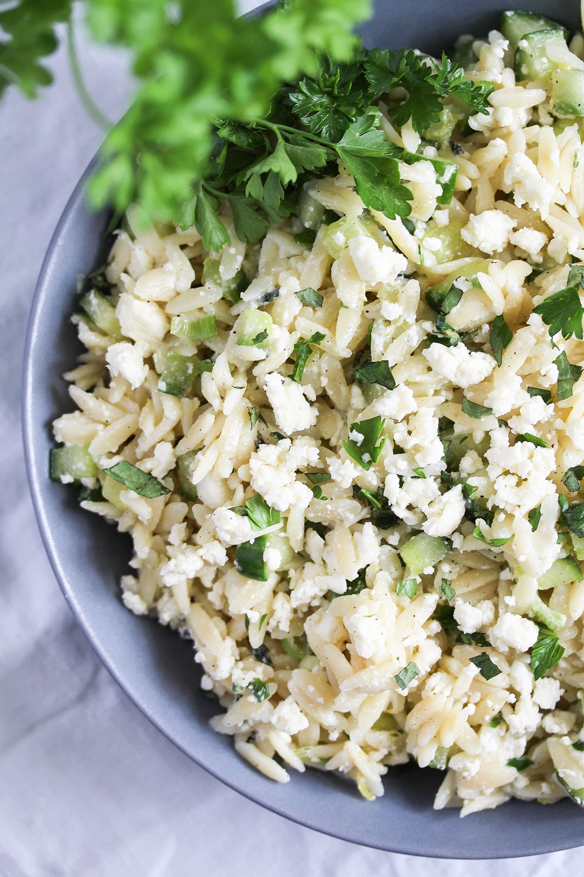 feta orzo salad with cucumbers and mint in a bowl.