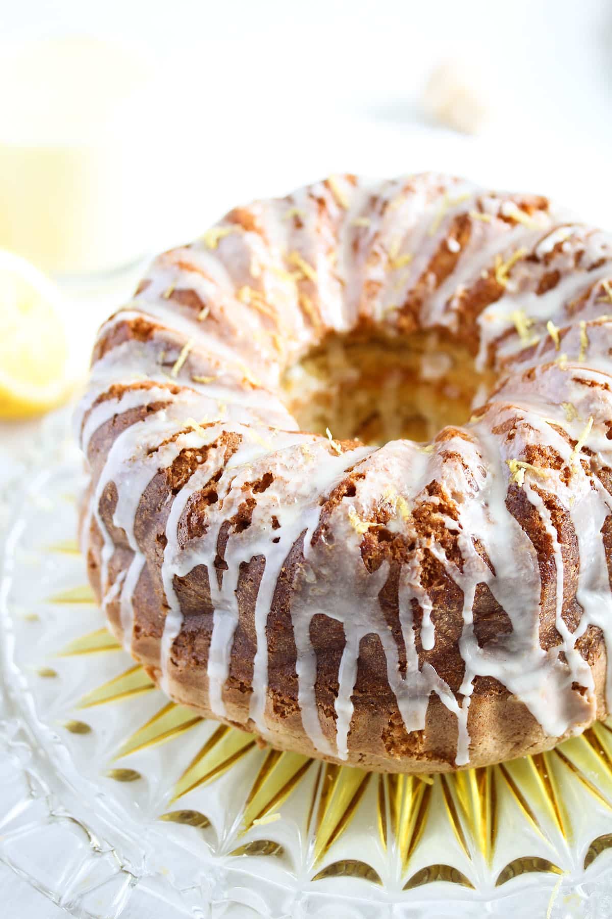 whole limoncello cake with drizzle on a platter.