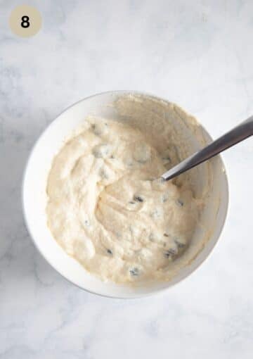 quark, egg, and raisin mixture for adding to romanian pasca in a bowl.