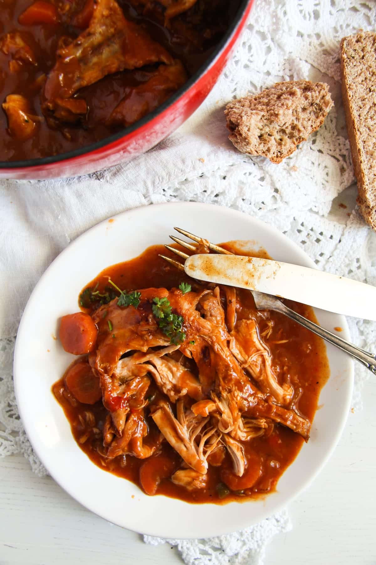 plate with shreded rabbit meat in rich sauce.