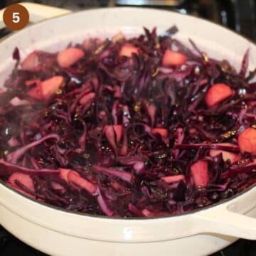 cooking red cabbage with apple pieces in a large pot.