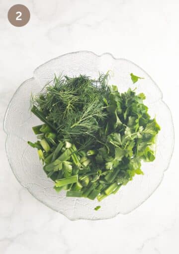 roughly chopped green onions and garlic, fresh parsley and dill in a large bowl.