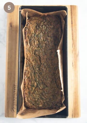 romanian drob baked in a loaf tin lined with parchment paper on a wooden board.