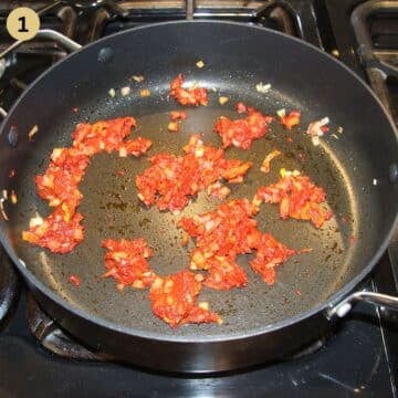 sauteing chopped onions and tomato paste in a large saucepan to make stew.