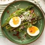 aspargus breakfast with eggs on toast on a green plate.