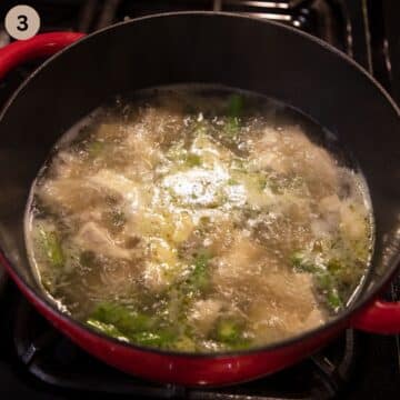 bubbling soup with asparagus and chicken in a large pot.