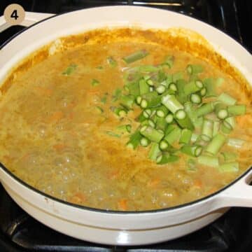adding asparagus pieces to coconut and vegetable curry.