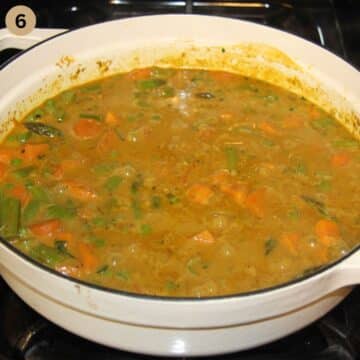simmering pot of curry with asparagus, vegetables and coconut milk.