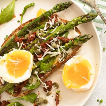 asparagus and a halved soft boiled egg on toast.