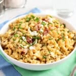 egg salad pasta salad in a bowl on a green and blue kitchen cloth.