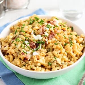 egg salad pasta salad in a bowl on a green and blue kitchen cloth.