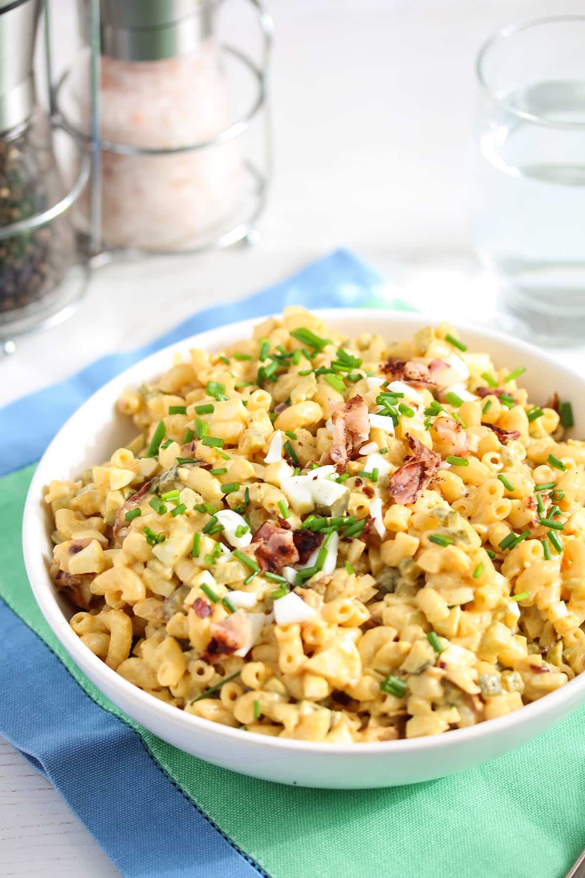 pasta salad with egg salad, bacon and chives in a bowl.